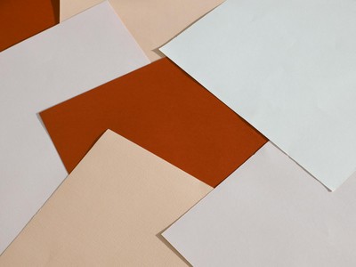 From above of blank paper sheets of different colors scattered on table as abstract background